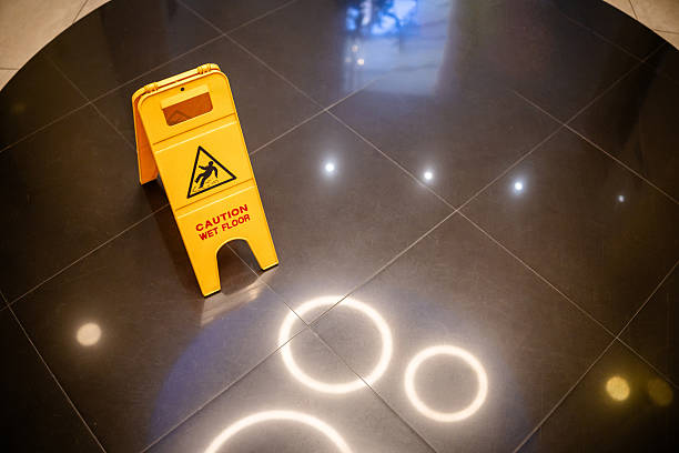 Man slips falling on wet floor next to the wet floor caution sign.