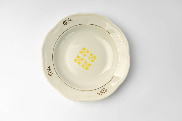 Empty restaurant dinner plate shot from above, isolated on white background. Classic elegant dish features a simple, yet stylish design, perfect for any table setting.