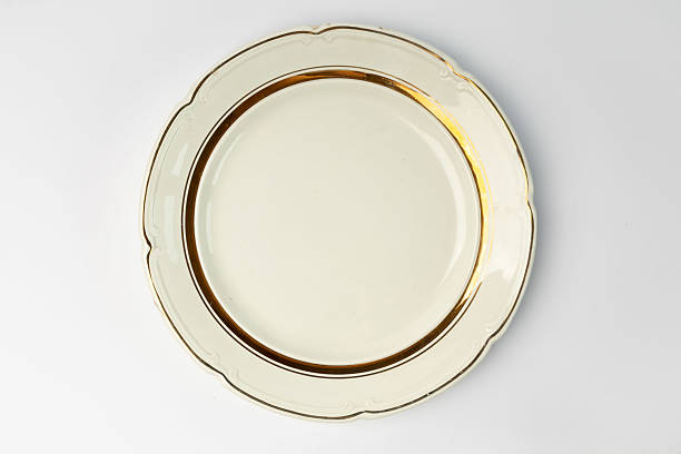 istock Empty restaurant dinner plate shot from above, isolated on white background. Classic elegant dish features a simple, yet stylish design, perfect for any table setting. 2215234421