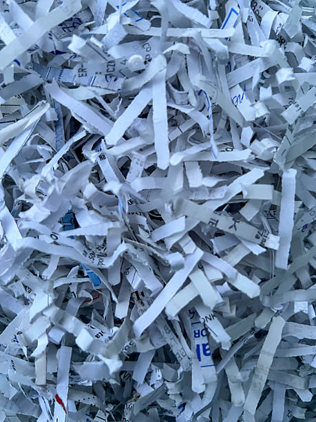 istock Pieces of cut paper documents pulled out of shredder as background. 2215235207