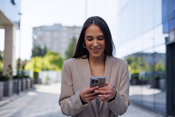 istock Professional female professional navigating busy urban sidewalk, working on mobile device with confident smile during morning commute 2215235836