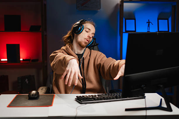 istock Male hipster with zombie addiction gesture while playing video game on computer at home 2215241215