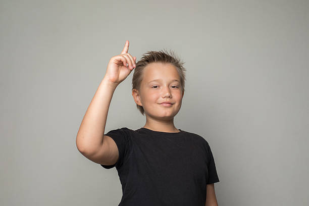 istock Handsome young boy child pointing finger up on white background 2215244718