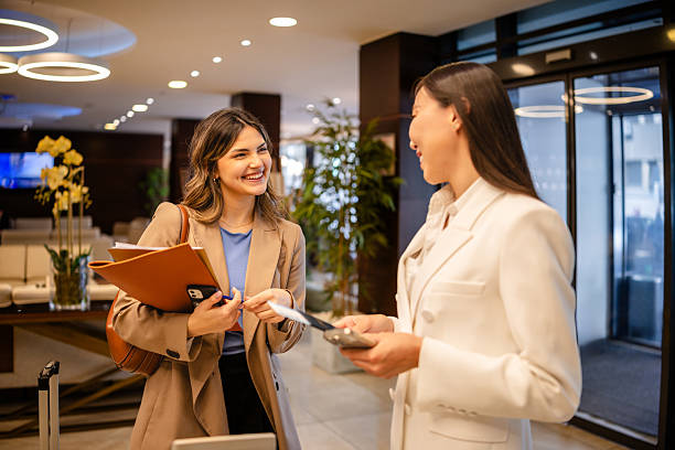 istock Young businesswomen interacting in a luxury hotel lobby while making reservations and discussing travel plans 2215251315