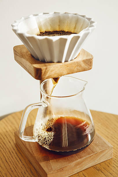 istock Close-up of Coffee Being Brewing Using an Alternative Method With Funnel is Origami Type and Stand from Which Drink Flows into Transparent Glass Pot 2215252405