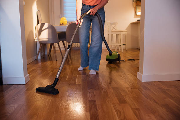 istock Young Woman Vacuuming Her Apartment 2215253209