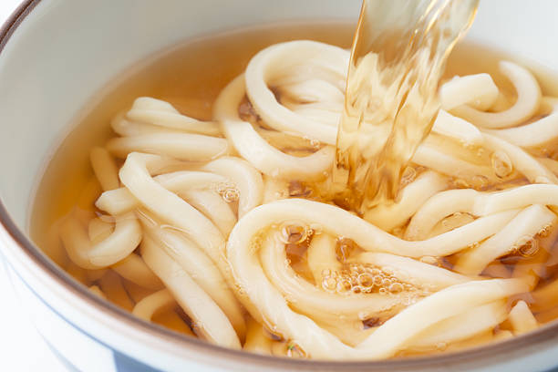 Pouring dashi broth over delicious-looking udon noodles