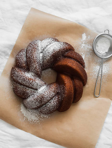 Directly above a whole sponge cake in a white plate on colored background with clipping path