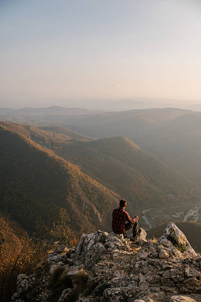 istock Man sitting at the cliff with scenic view 2215259230
