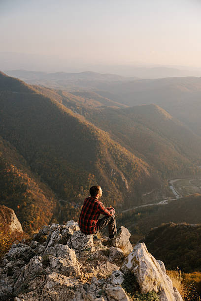 istock Man sitting at the cliff with scenic view 2215259232
