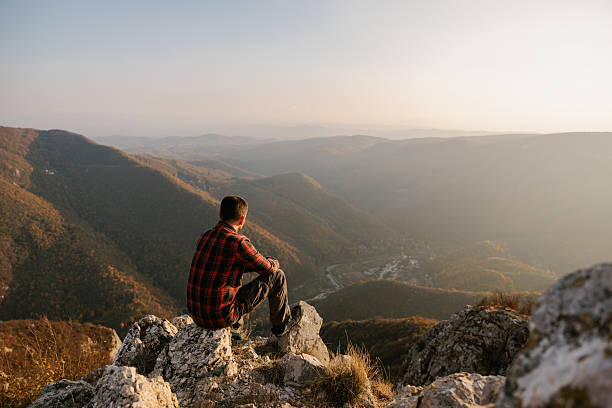 istock Man sitting at the cliff with scenic view 2215259244