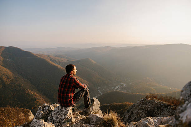 istock Man sitting at the cliff with scenic view 2215259245