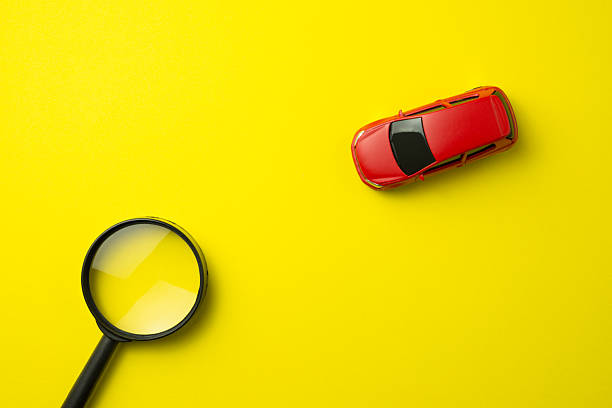 istock Red car and magnifying glass on yellow background with copy space. 2215261153