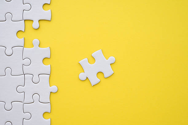 istock Unfinished white jigsaw puzzle on yellow background with copy space. 2215261178