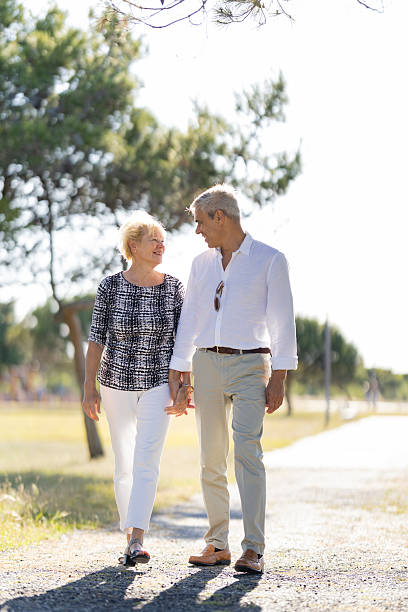 istock Happy senior couple walking in park holding hands 2215262821