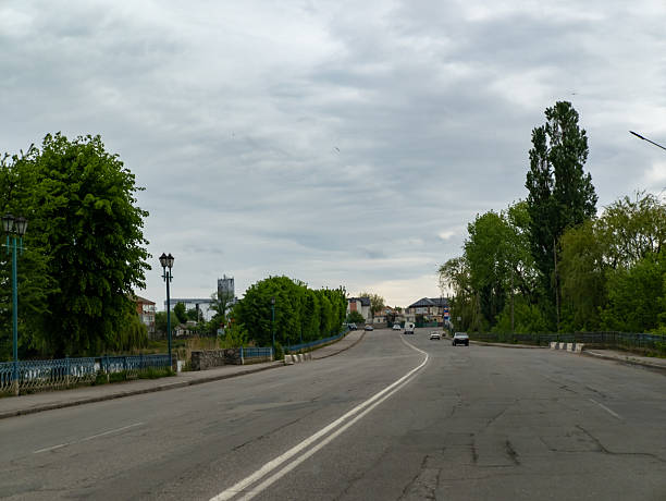 istock An empty street with cars driving down it 2215264923