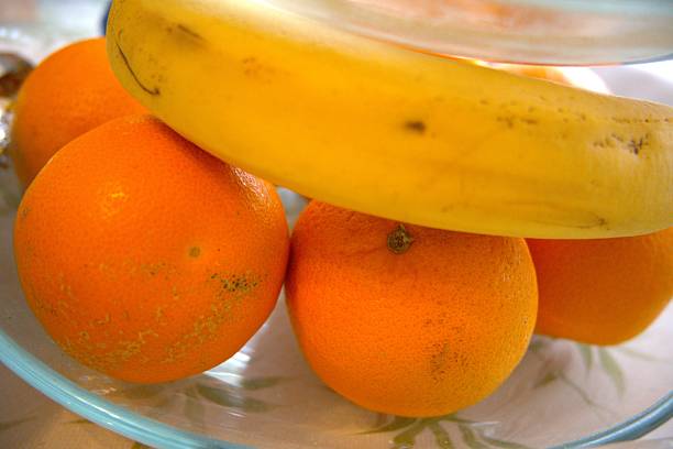 Oranges and banana on glass plate
