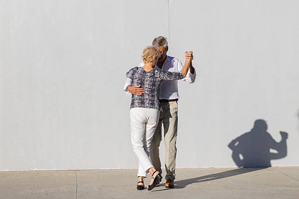 istock Senior couple dancing tango in front of white wall 2215266227