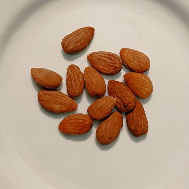 istock A handful of almonds on a white surface. 2215268872