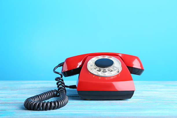 istock Red retro telephone on wooden table 2215271887