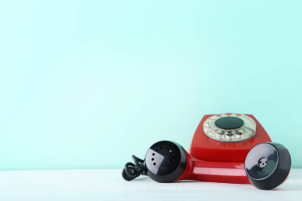 istock Red retro telephone on white wooden table 2215273689