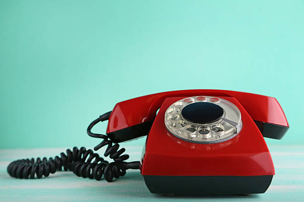 istock Red retro telephone on wooden table 2215273791
