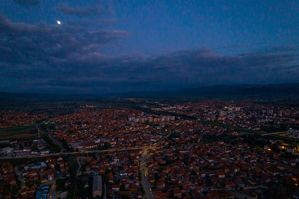 istock Moon shining over cityscape at dusk with cloudy sky 2215274716