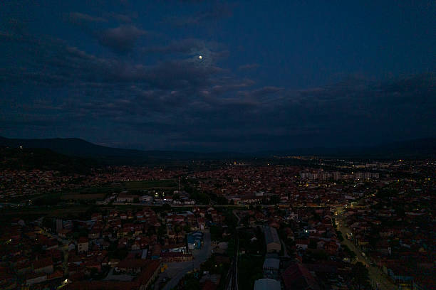 istock Moon shining over city at night with cloudy sky 2215274922