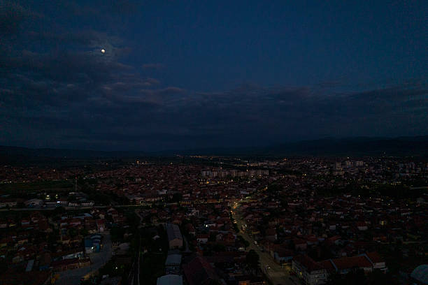 istock Moon rising over a small city at night 2215275241