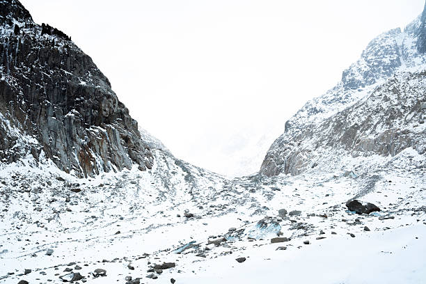 Snowy glacier valley with rocky cliffs and frozen terrain in chamonix