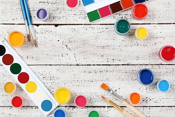 istock Colorful gouache paints and brushes on white wooden table 2215278454
