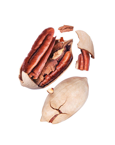 istock Whole and crushed pecan nuts close-up on white background in the air 2215280678