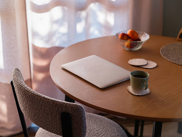 istock Morning Ritual: Sunlit Oak Table with Laptop and Tangerines 2215280799