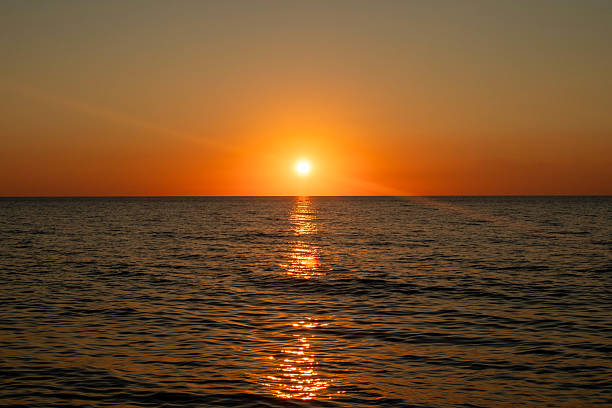istock The sun is setting over the ocean, casting a warm glow on the water 2215281800