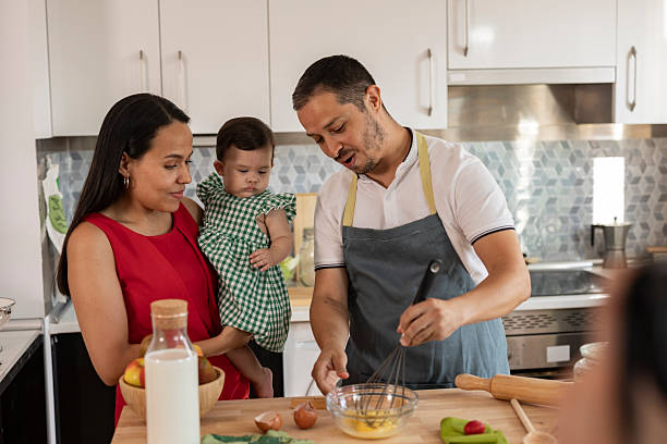 istock Hispanic family cooking together in modern kitchen, whisking eggs 2215283400