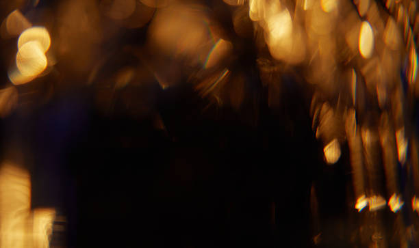 Abstract light leaks on black background with copy space. Studio lens flare bokeh effect.