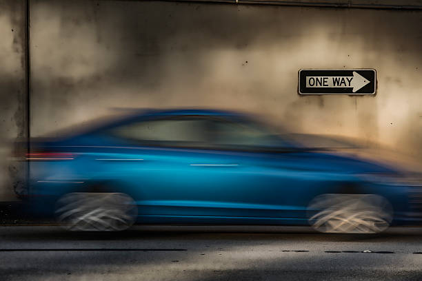 One way sign, moving car, motion blur, late afternoon.