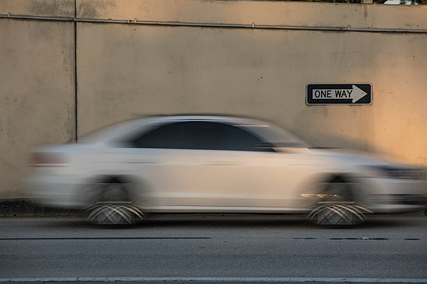 istock One Way Sign with Moving White Car 2215287537