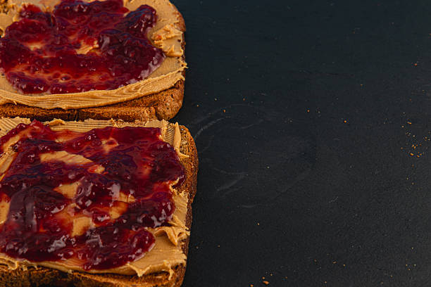 istock Peanut butter and jelly spread on toasted bread slices 2215294521