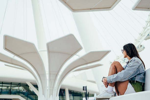 Young woman relaxing under modern architectural structure