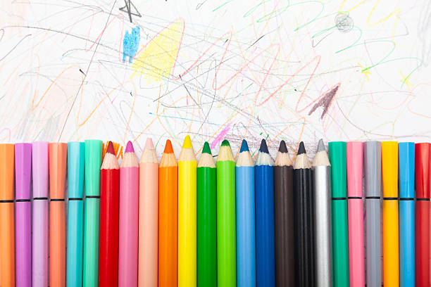 istock Multi-colored pencils lie on white paper drawn with multi-colored curved lines. 2215300677