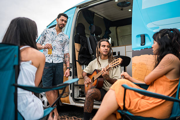 istock Diverse Young Adults Relaxing by Campervan with Guitar on a Sunny Day 2215301243