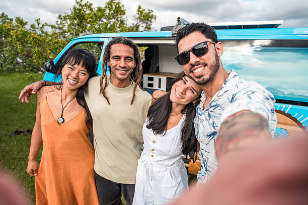 istock Diverse Young Adults Smiling Outdoors Near a Blue Camper Van on a Fun Camping Adventure 2215301281