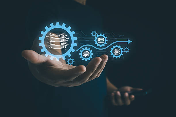 istock Businessman holding a digital gear icon symbolizing the ETL process in cloud data management, surrounded by related technology icons. AI industrial and smart business and automation solution. 2215303289