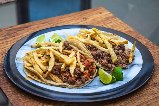 Mexican beef jerky tacos with fries on top and lemons on the side, tacos from Mexico City and Mexico State, edomex