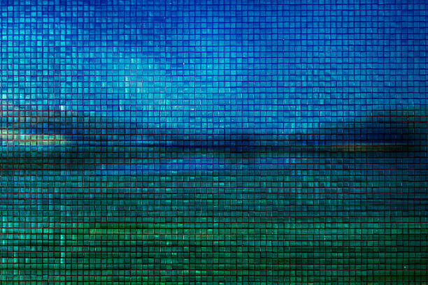 A digitally manipulated photograph that turns a tranquil seascape into a captivating tile-like pattern. Created using a mosaic filter in post-production, the image overlays tiny, textured grid squares across a scenic blend of blue skies and green waters. The result is a modern and abstract representation that resembles handcrafted ceramic tiles.