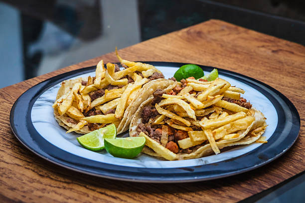 Mexican beef jerky tacos with fries on top and lemons on the side, tacos from Mexico City and Mexico State, edomex