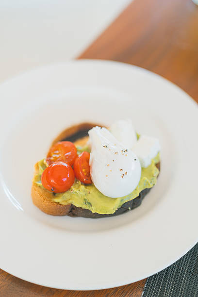 Overhead view of avocado on toast with tomatoes and mozzarella cheese