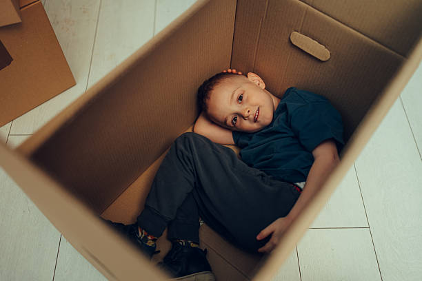 istock Young child relaxing inside cardboard box at home 2215309445