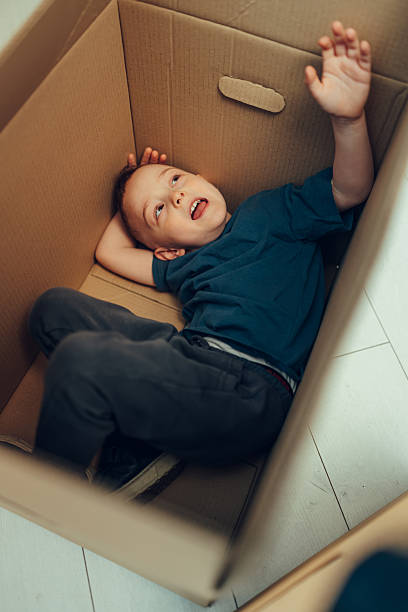 istock Happy child playing inside cardboard box at home 2215309446